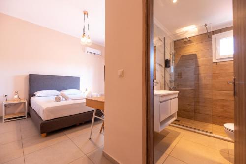 a bedroom with a bed and a bathroom with a shower at Stone Palace Hotel Near Athen's Airport Free Shuttle From and to Athen's Airport in Spáta