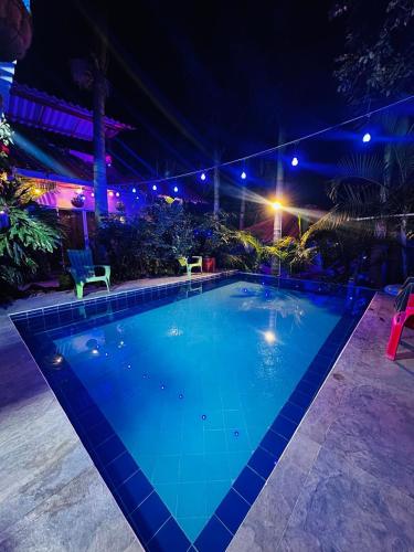 a large blue swimming pool at night at Hostal Hilltop Salento in Salento