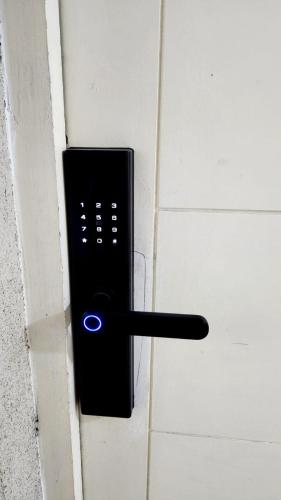 a black door handle with a blue light on it at Departamentos Amoblados Chileruca in Santiago
