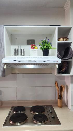 a kitchen with a stove top in a kitchen at Departamentos Amoblados Chileruca in Santiago