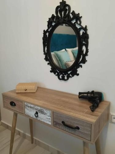 a mirror sitting on top of a wooden table at Thanos Cozy Apartments in Skala Kallonis