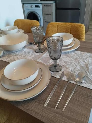 a table with plates and glasses and silverware on it at Thanos Cozy Apartments in Skala Kallonis