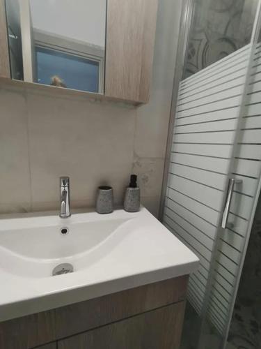 a bathroom with a white sink and a mirror at Thanos Cozy Apartments in Skala Kallonis