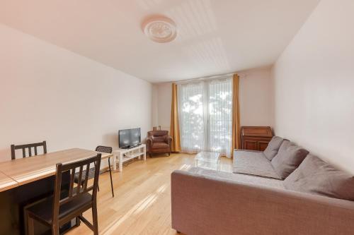 a living room with a couch and a table at Appartement vue sur Lac proche métro in Créteil