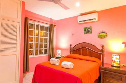 a bedroom with a bed with two towels on it at Hotel Maria's Nicte Ha in Progreso