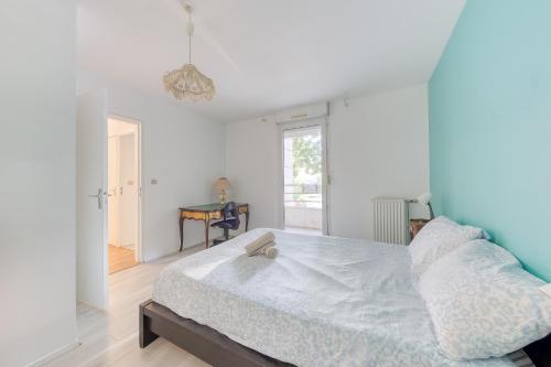 a white bedroom with a bed and a window at Appartement vue sur Lac proche métro in Créteil
