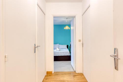 a hallway leading to a bedroom with a bed at Appartement vue sur Lac proche métro in Créteil