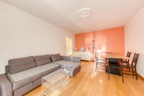 a living room with a couch and a table at Appartement vue sur Lac proche métro in Créteil