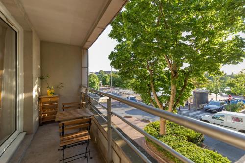 a balcony with benches and a tree on a building at Appartement vue sur Lac proche métro in Créteil