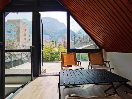 two chairs sitting in a room with a large window at 华山隐泉禅境 山景观星禅修别墅 Hua Shan Hidden Spring Restore Villa in Huayin