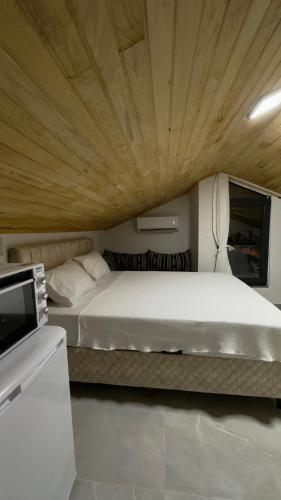 a bedroom with a large bed with a wooden ceiling at Villa Burçin Apart in Dalyan