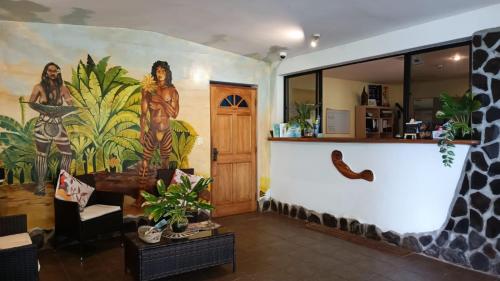 a living room with a large mural on the wall at Hotel Gomero in Hanga Roa
