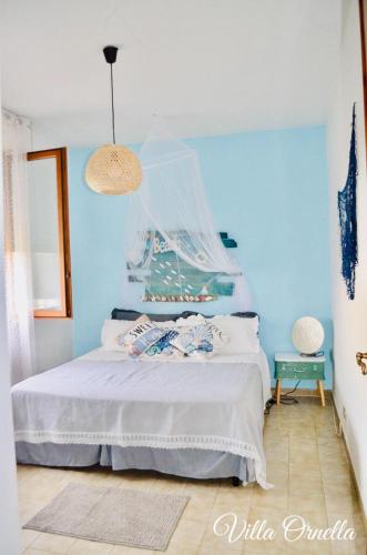 a bedroom with a bed with a blue wall at Villa Ornella in Luni