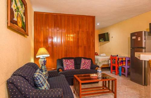 a living room with two couches and a table at Hotel Maria's Nicte Ha in Progreso