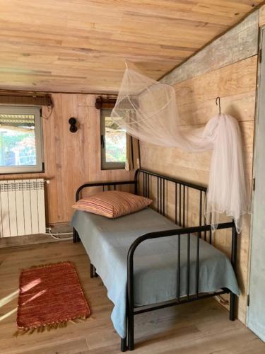 a bedroom with a bed in a room with wooden walls at Cabana do Dinamarquês em Arga de Baixo in Arga de Baixo