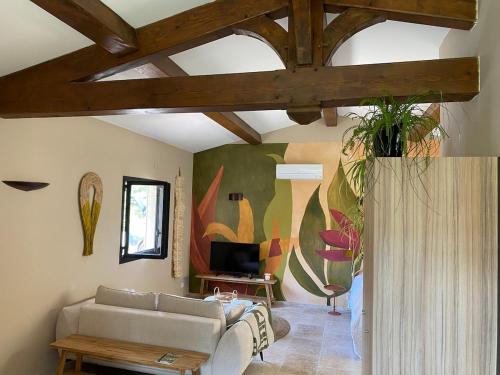 Una sala de estar con un sofá y un televisor. en Le mazet Tihou - Le mas du tilleul, en Le Beausset