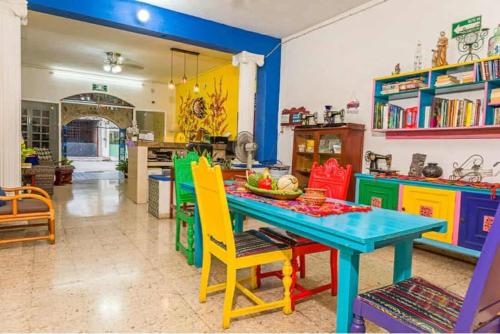 a dining room with a blue table and colorful chairs at Hotel Maria's Nicte Ha in Progreso