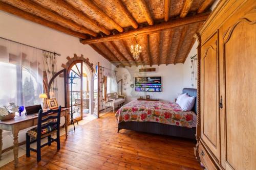 a bedroom with a bed and a wooden ceiling at A historic STONE VILLA with private garden, terrace and private pool just for you in Kliru
