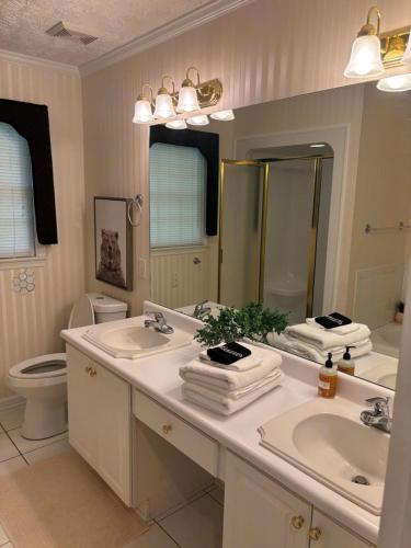 a bathroom with two sinks and a toilet and a mirror at The Mirror Lake Suite in Fayetteville