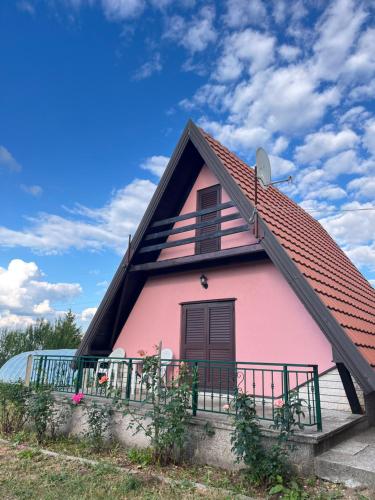 a pink house with a red roof at Vikendica Ksenija in Jasikovice