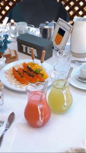 a table with a plate of food and two glasses of juice at Casa Valldemossa in Búzios