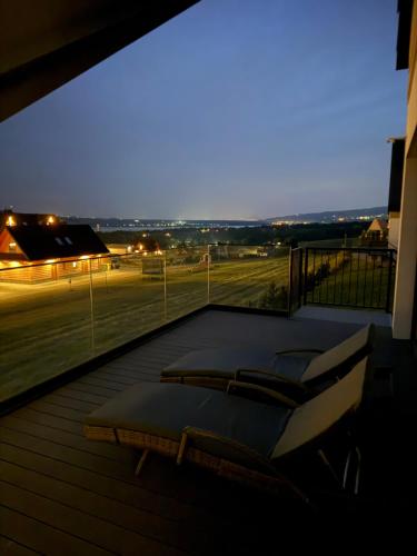 a balcony with chairs and a view of a soccer field at CzorsztynLakePL in Kluszkowce