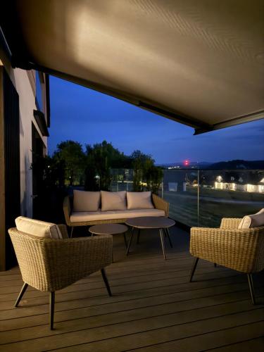 a balcony with a couch and chairs and a table at CzorsztynLakePL in Kluszkowce