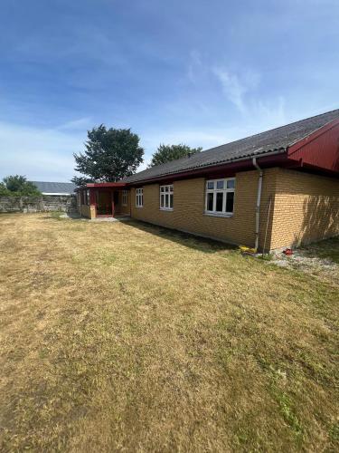 a house with a large yard next to a building at Waves & Waterslides in Rødby
