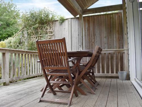 a wooden table and chairs sitting on a porch at Lo-Tide in Middleton-on-Sea