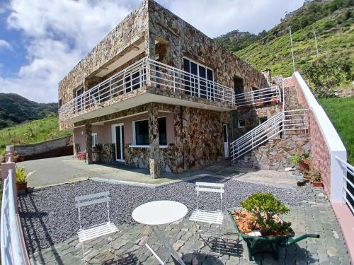 a stone house with a table and chairs on a patio at São Lourenço 3 in Caniçal