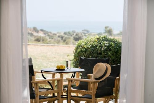 a table and two chairs with a hat on a patio at Scala Apartments in Kastraki Naxou