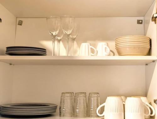 einen Schrank mit Tellern, Weingläsern und Geschirr in der Unterkunft Hotel Alumine in Villa Cura Brochero