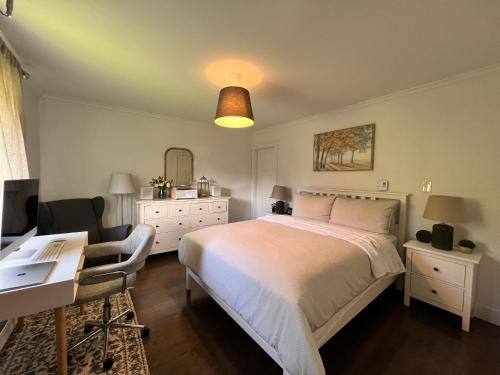 ein Schlafzimmer mit einem weißen Bett und einem Schreibtisch in der Unterkunft LF Guesthouse in Nanaimo