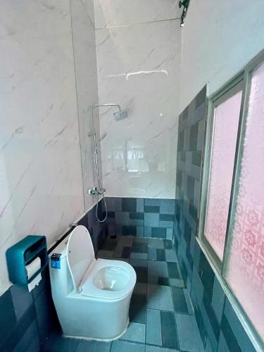 a bathroom with a white toilet and a shower at Bảo Bảo guest houes in Bắc Hà