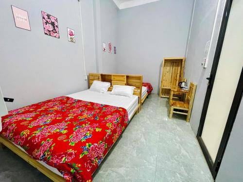 a bedroom with a bed with a red blanket at Bảo Bảo guest houes in Bắc Hà