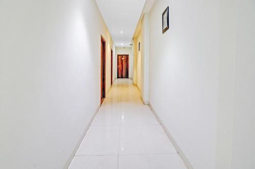 an empty corridor with white walls and a long hallway at Townhouse Sulit in Tājganj