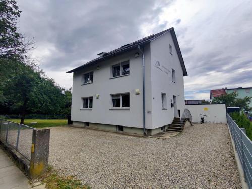 a white house sitting on top of a gravel lot at Ferienhaus Bailey in Laupheim