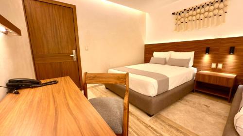 a hotel room with a bed and a desk at Hotel Makkan Boca in Veracruz