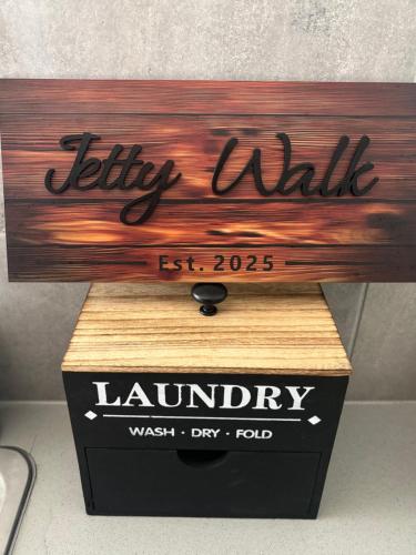 a wooden sign on top of a box at JettyWalk, Stunning 3br townhouse, walk to beach in Rosebud