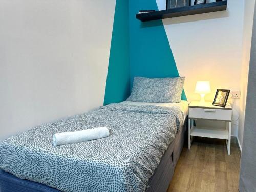 a bedroom with a bed with a blue wall at delightful Partition Room Barsha Heights Tecom in Dubai