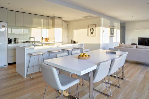 a kitchen and living room with a white table and chairs at 381 Cremorne in Melbourne