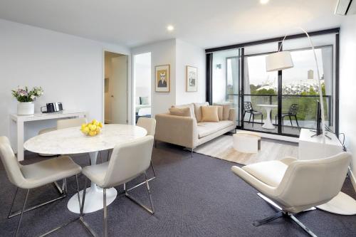 a living room with a white table and chairs at 381 Cremorne in Melbourne