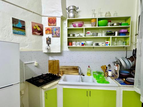 a kitchen with green cabinets and a sink at Joli appartement in Tunis