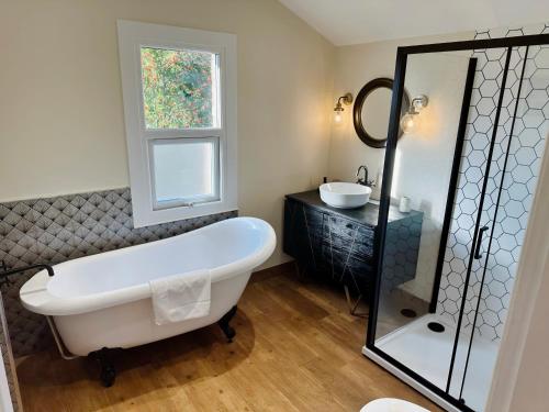 a bathroom with a bath tub and a sink at QUEENS RETREAT- Luxe 3-Bed Comfort, Sleeps 6, PERMITTED PARKING FOR 2 CARS, Pet-friendly & close to bars and Restaurants in Lincoln