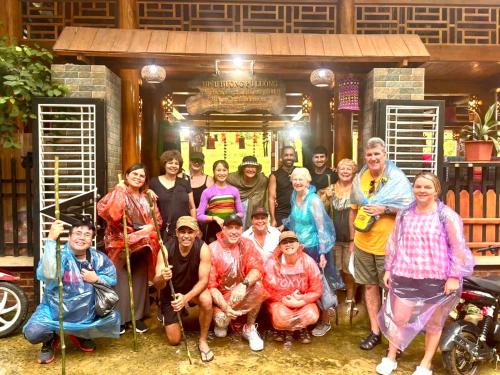 a group of people posing for a picture in front of a building at Hiếu Hương Homestay in Lũng Tiềm