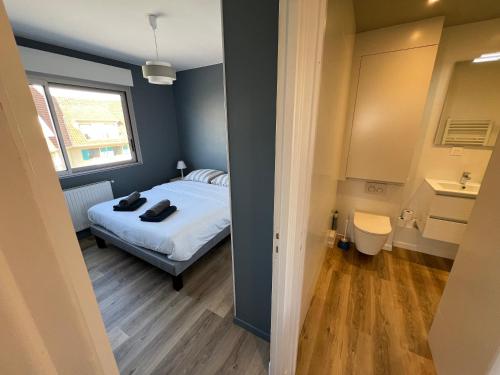 een kleine slaapkamer met een bed en een raam bij Le Grand Large Front de Mer in Le Touquet-Paris-Plage