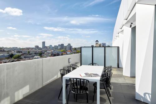 a white table and chairs on a balcony with a view at 381 Cremorne in Melbourne