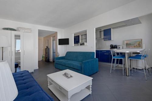 un salon avec un canapé bleu et une table dans l'établissement Confort & Calme 5 pers Rue des Mariniers, à Paris