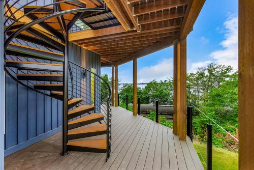 a wooden deck with a spiral staircase on a house at Stonegrove Residence in Blaine