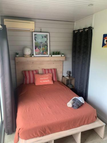a bed with a red comforter in a bedroom at T2 Beausoleil in Les Abymes